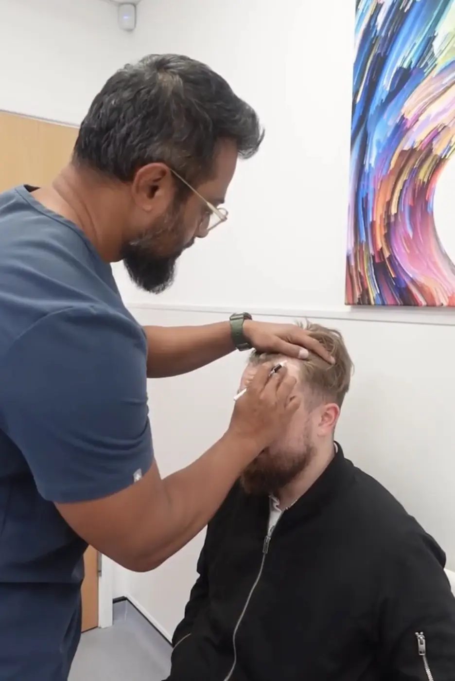 Surgeon examining a patient's hairline