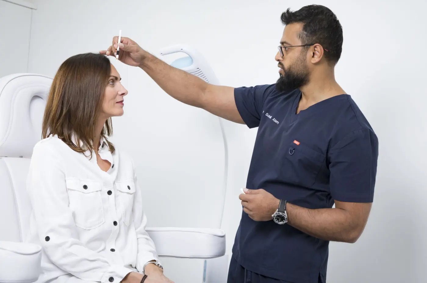 Doctor assessing a patient's hairline during a consultation